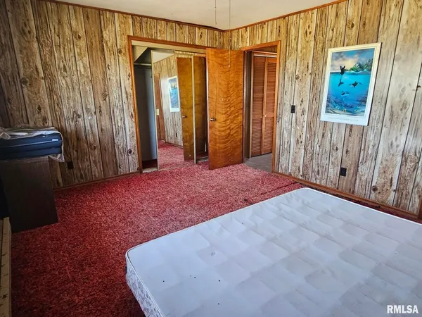 a view of a bedroom with wooden floor and walls