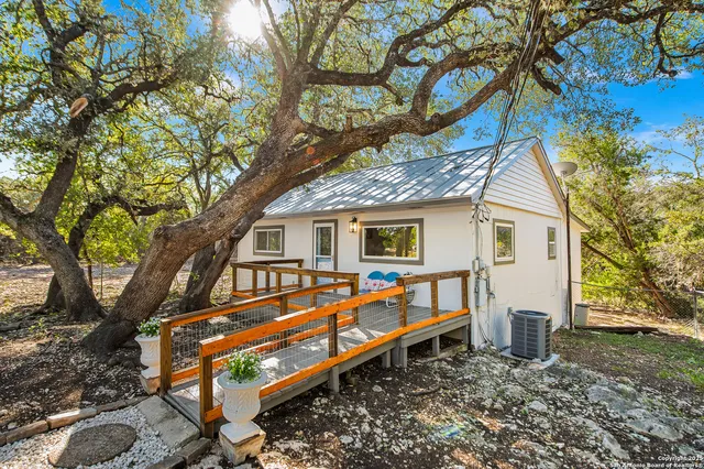 a house view with a backyard and a tree