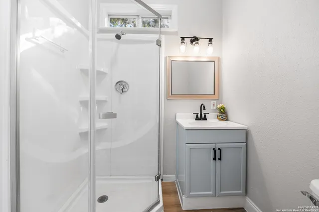 a bathroom with a sink a toilet and shower