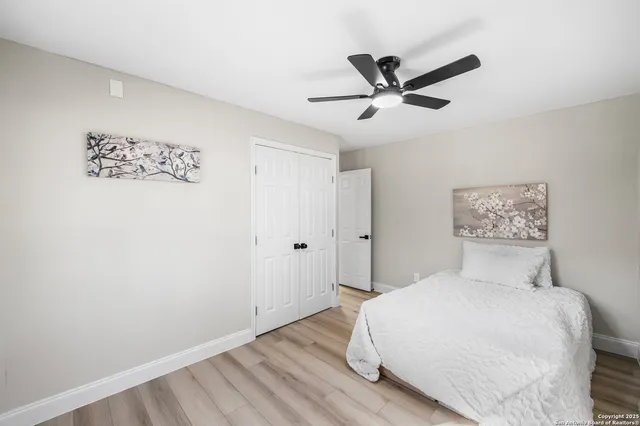 a bedroom with a large bed and a ceiling fan