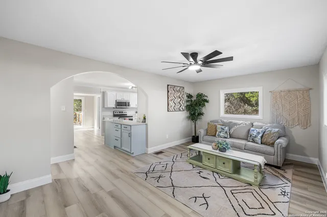 a living room with furniture and a large window with wooden floor