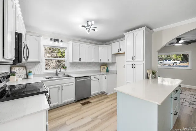 a kitchen with granite countertop a sink stove and refrigerator