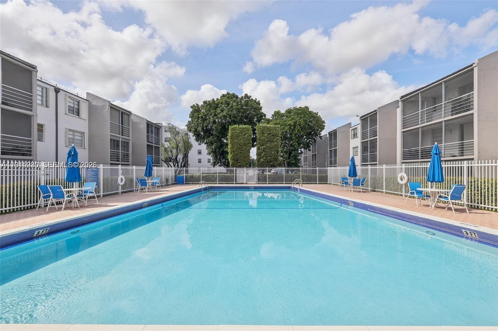14170 Southwest 84th Street, Unit 404F Miami, FL 33183 - Photo 12 of 18 a swimming pool with outdoor seating and yard in the back