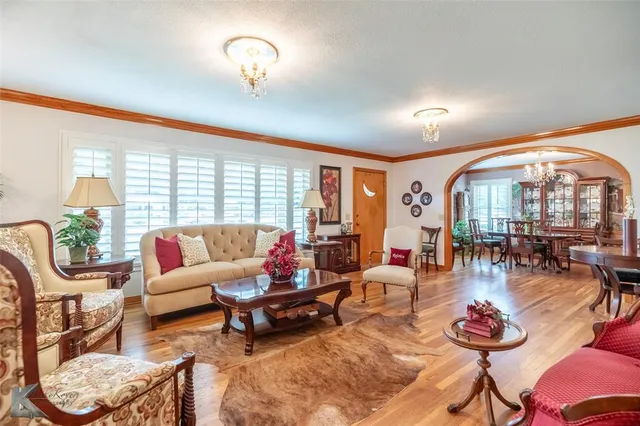 a living room with furniture a floor to ceiling window and a flat screen tv