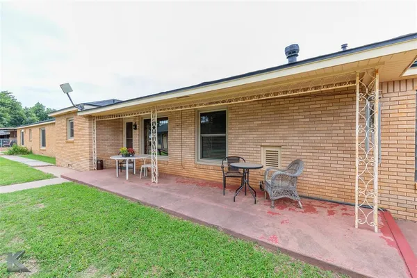 a view of a house with patio and a yard
