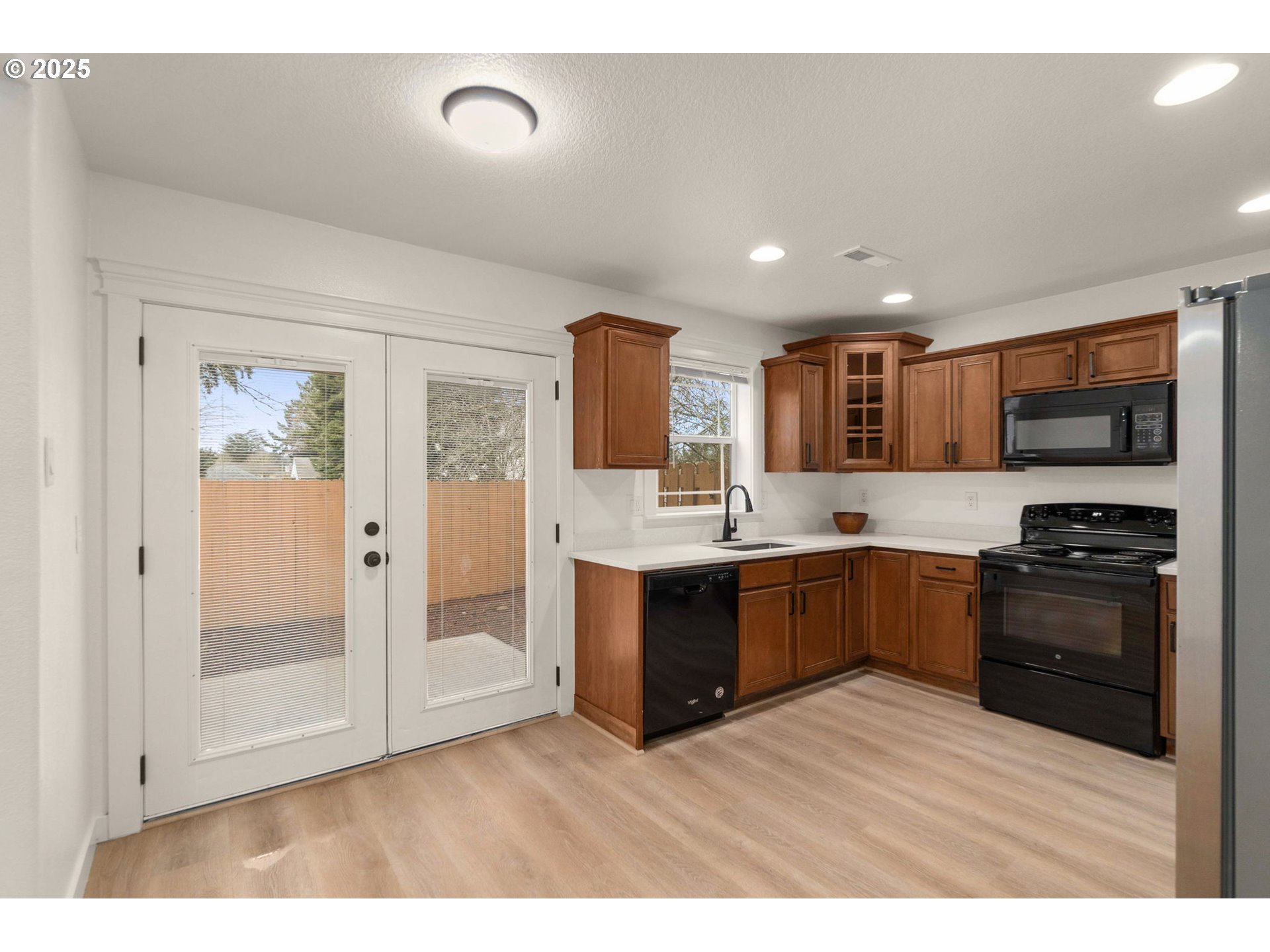 14553 Southeast Rhine Street Portland, OR 97236 - Photo 12 of 26 a large kitchen with a sink and stainless steel appliances