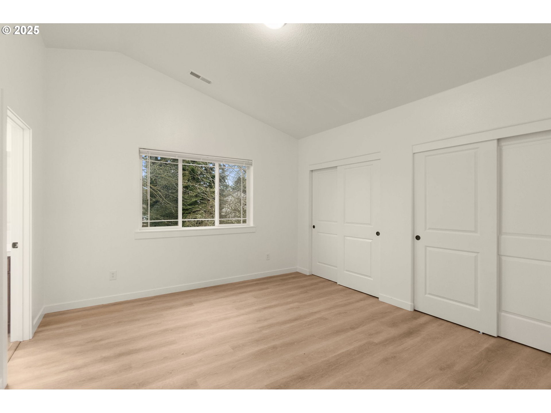 14553 Southeast Rhine Street Portland, OR 97236 - Photo 17 of 26 a view of an empty room with wooden floor and a window