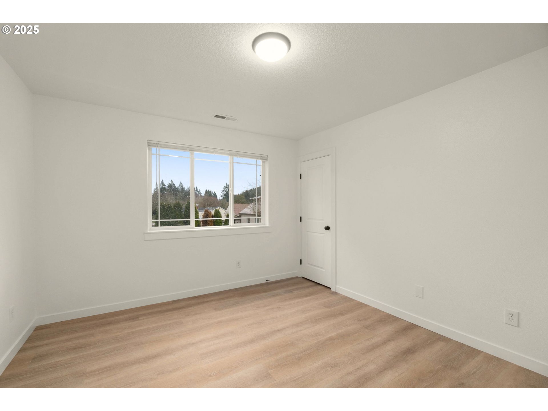 14553 Southeast Rhine Street Portland, OR 97236 - Photo 20 of 26 an empty room with wooden floor and windows