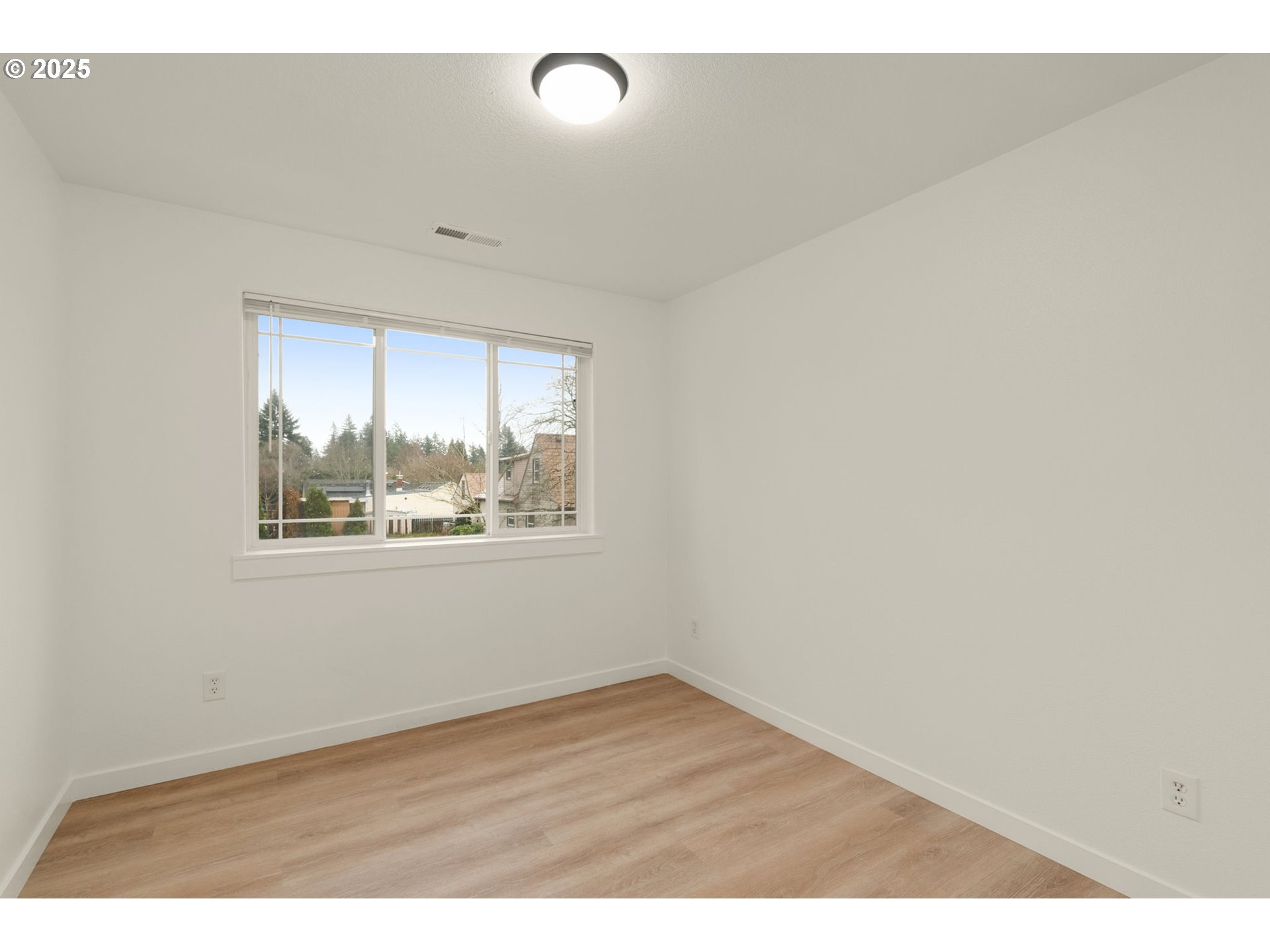 14553 Southeast Rhine Street Portland, OR 97236 - Photo 21 of 26 an empty room with wooden floor and windows