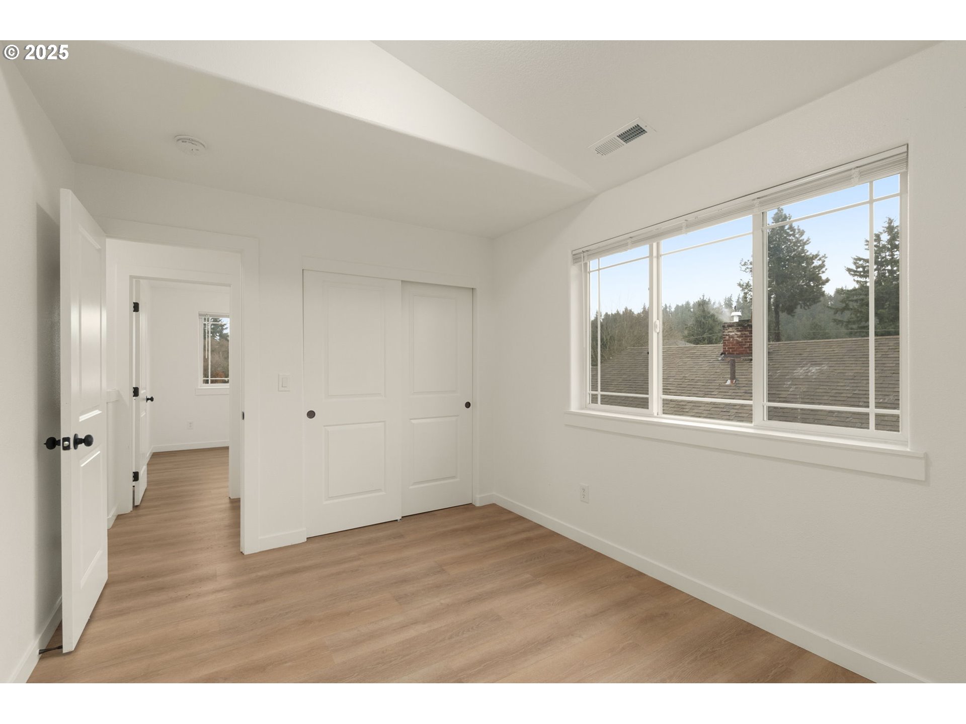 14553 Southeast Rhine Street Portland, OR 97236 - Photo 22 of 26 a view of an empty room with wooden floor and a window