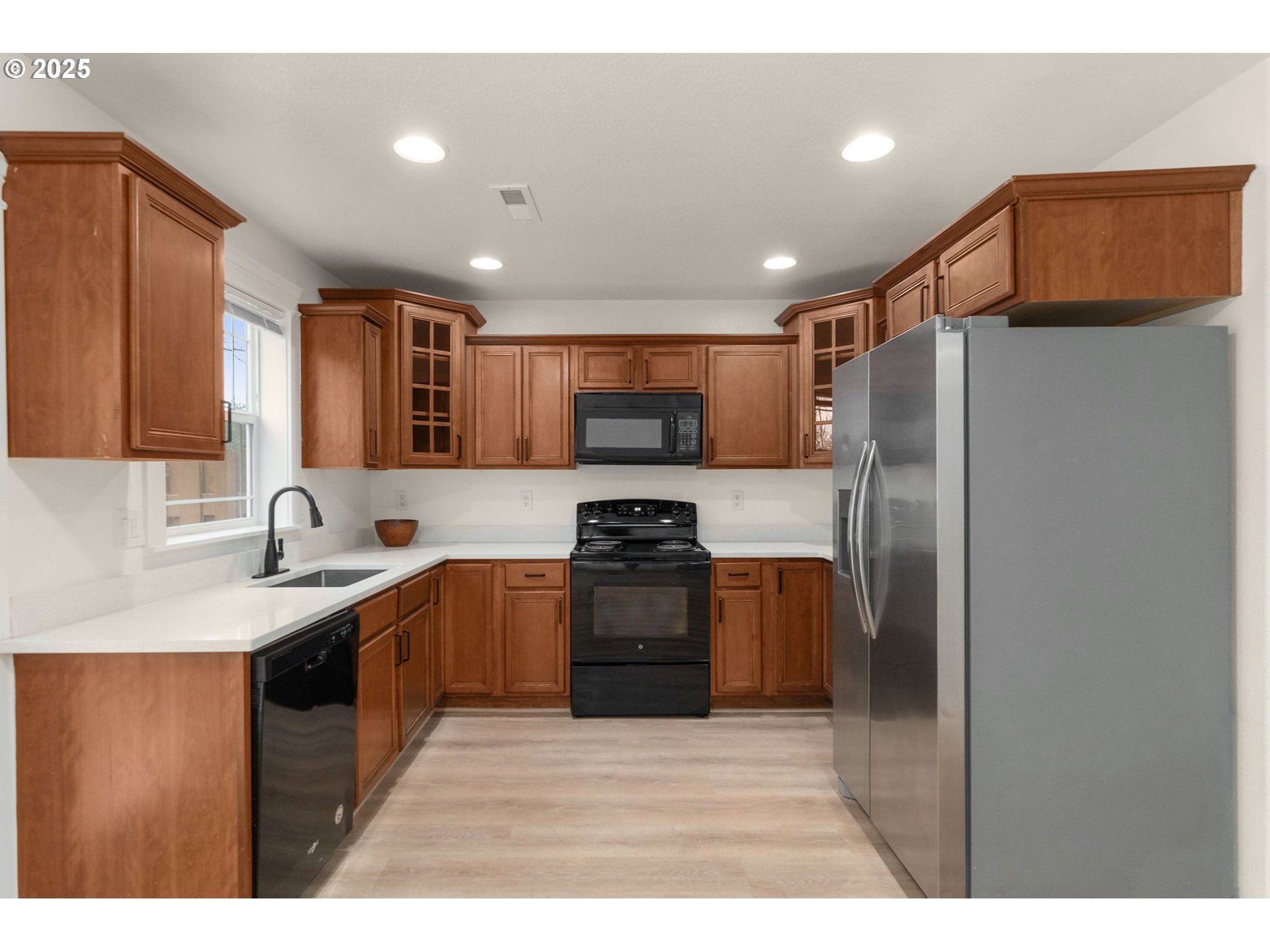 14553 Southeast Rhine Street Portland, OR 97236 - Photo 3 of 26 a kitchen with stainless steel appliances granite countertop a refrigerator a sink a stove top oven a counter space and cabinets