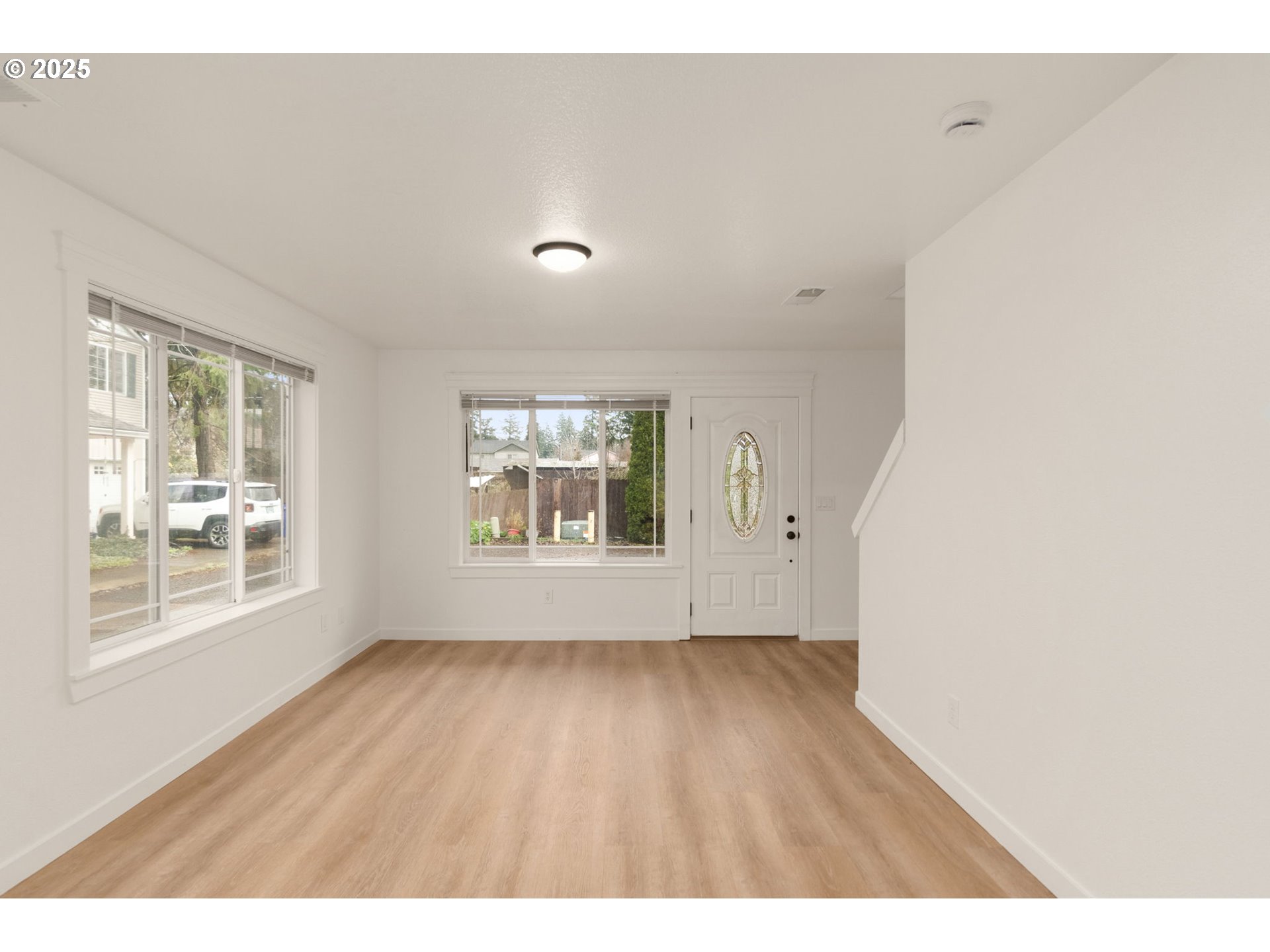 14553 Southeast Rhine Street Portland, OR 97236 - Photo 4 of 26 a view of an empty room with wooden floor and a window