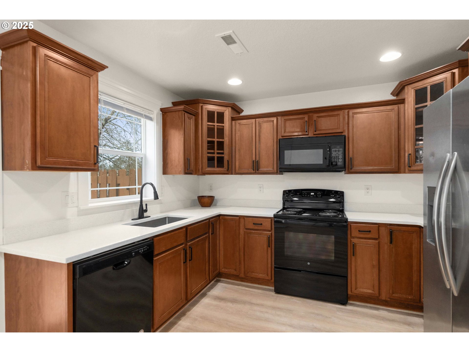 14553 Southeast Rhine Street Portland, OR 97236 - Photo 9 of 26 a kitchen with stainless steel appliances granite countertop a sink stove and refrigerator
