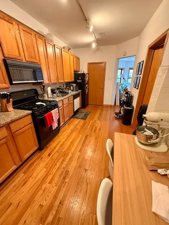 a kitchen with wooden floors and stainless steel appliances