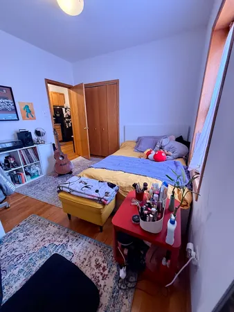 a bedroom with a bed and wooden floor