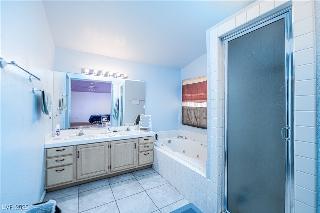 475 East Robindale Road Las Vegas, NV 89123 - Photo 12 of 41 Ensuite bathroom with double vanity, a tub with jets, a stall shower, and tile patterned flooring