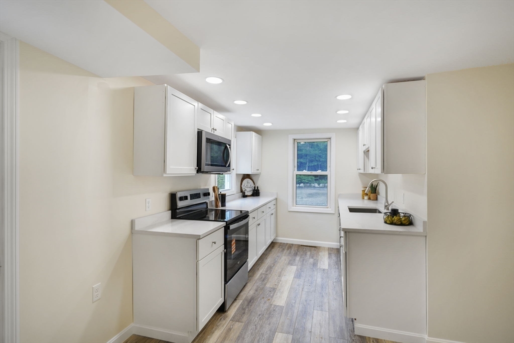 1030 Oak Street Dighton, MA 02764 - Photo 7 of 20 a kitchen with stainless steel appliances a stove top oven a sink a refrigerator white cabinets and wooden floor