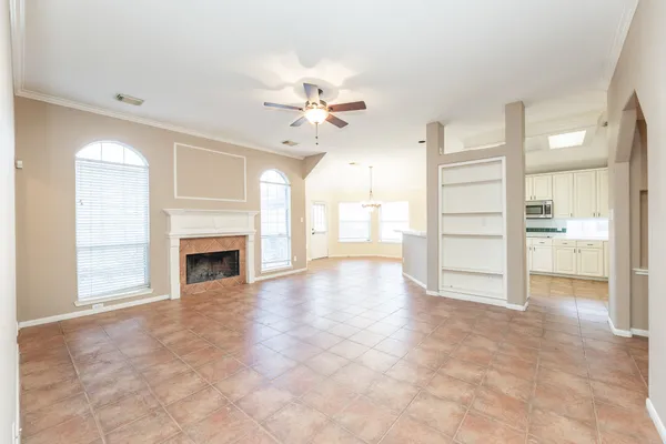 a view of a livingroom with a fireplace a chandelier and windows