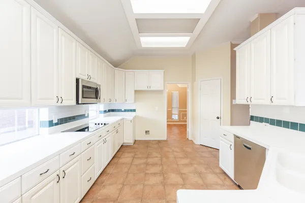 a large white kitchen with cabinets