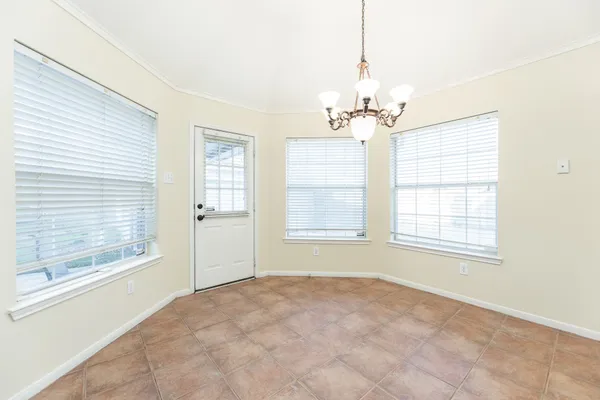 an empty room with fan and windows