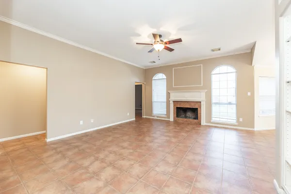 an empty room with windows and fireplace