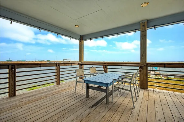 a view of a balcony with chairs and wooden floor