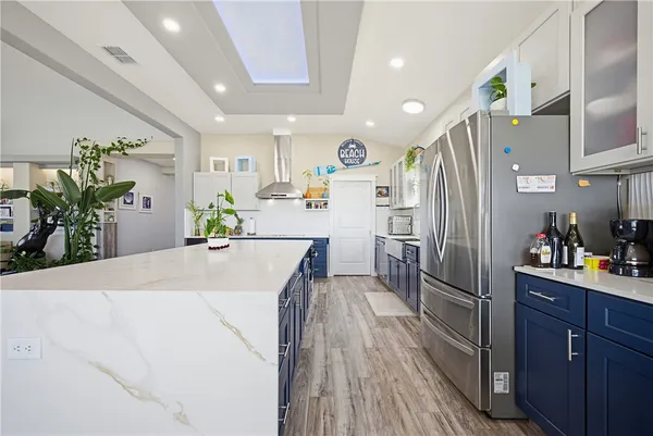 a kitchen with stainless steel appliances a refrigerator sink and wooden floor