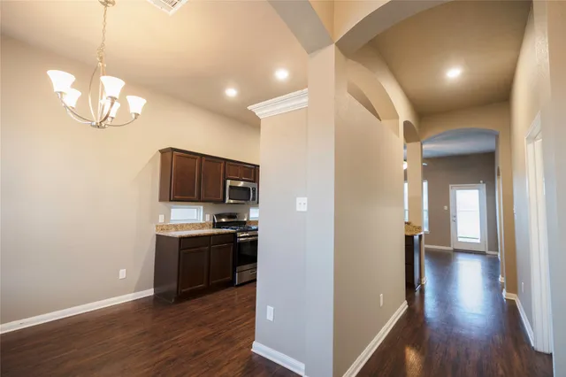 a view of a kitchen with a sink and dishwasher a refrigerator with wooden floor