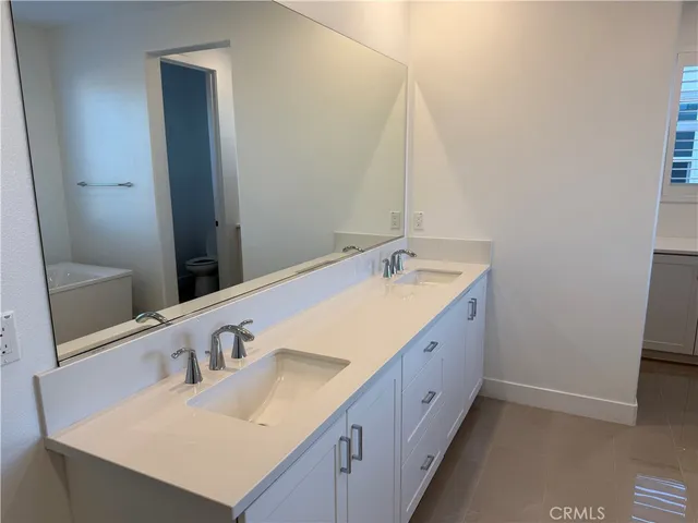 a bathroom with a double vanity sink and a mirror