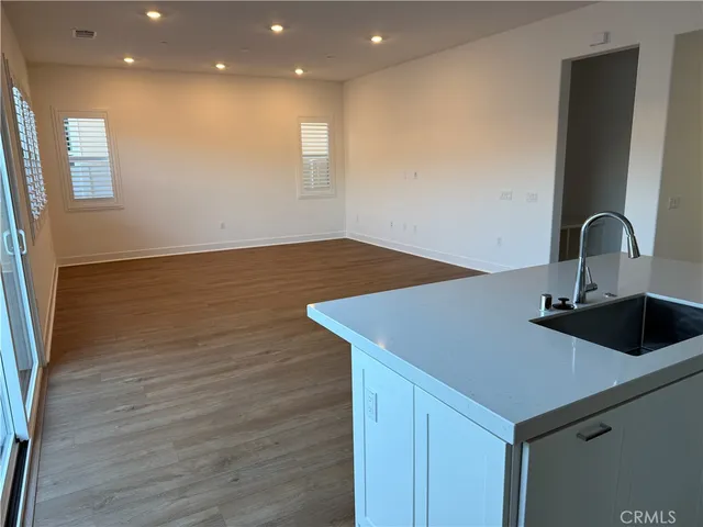 a kitchen with a sink cabinets and wooden floor