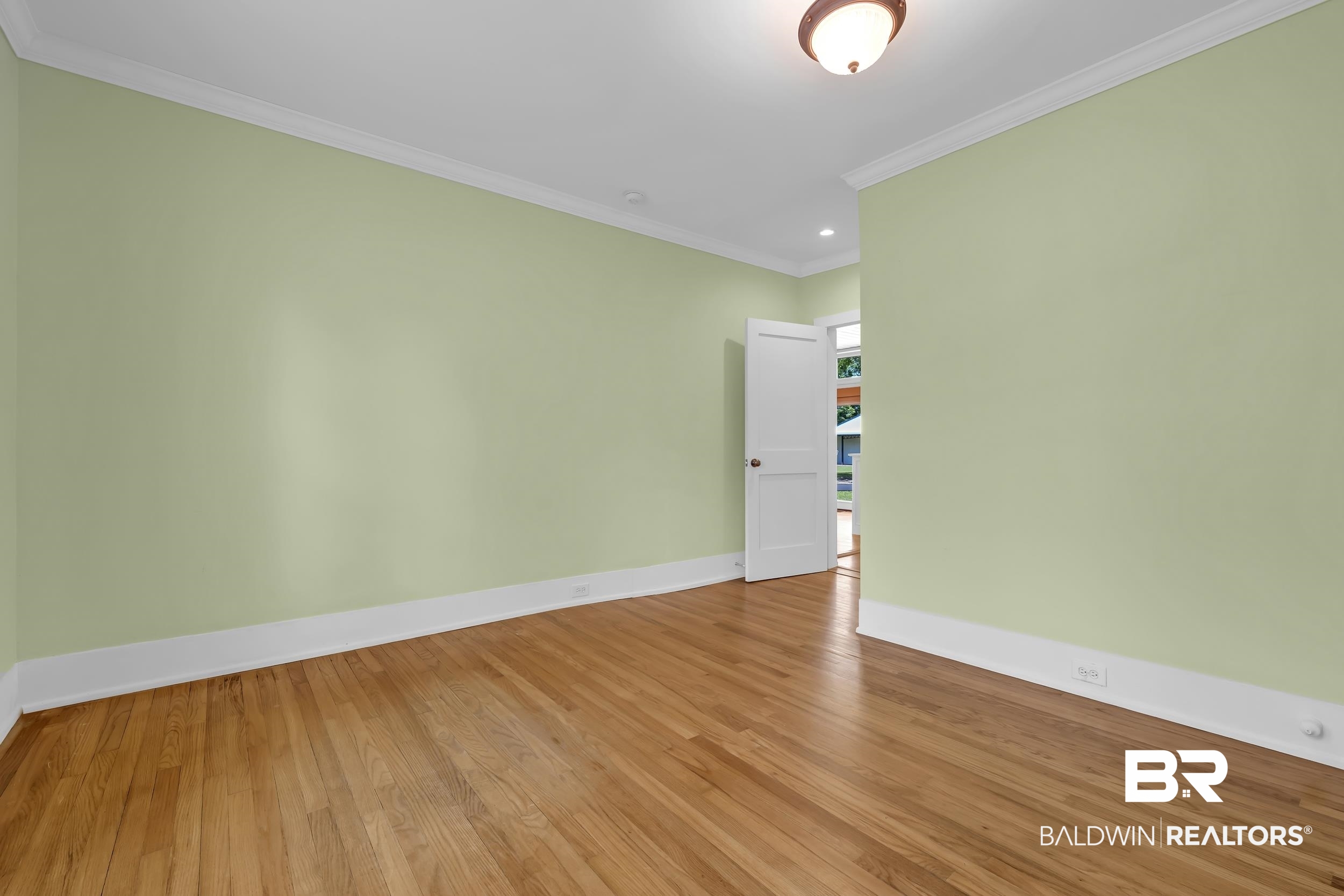43199 Pine Grove Road Bay Minette, AL 36507 - Photo 53 of 71 Interior room featuring wood-finish flooring, light green walls, and white crown molding