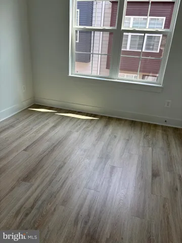 a view of a room with wooden floor and a window
