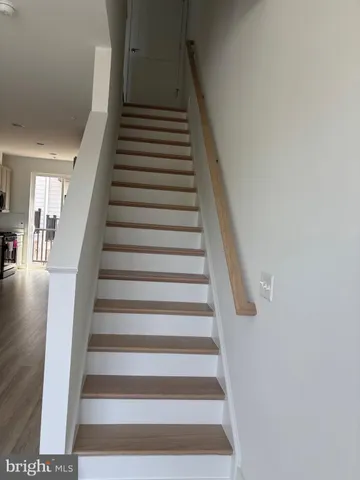 a kitchen with stainless steel appliances a refrigerator and wooden floor