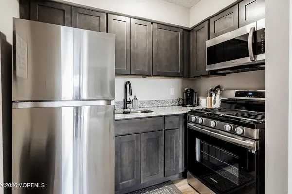 a kitchen with stainless steel appliances a refrigerator stove and microwave