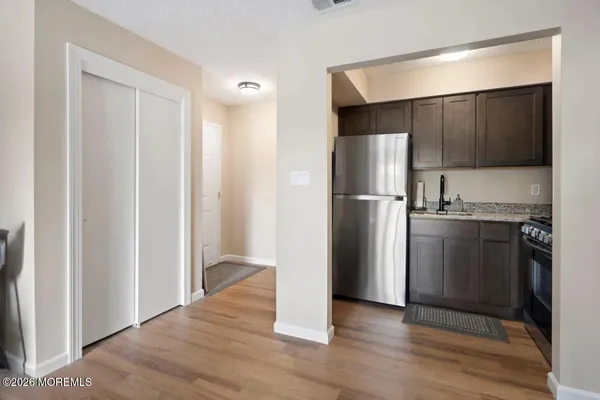 a view of a kitchen with a refrigerator a stove top oven and cabinets