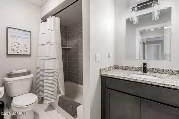 a bathroom with a granite countertop toilet sink and a mirror