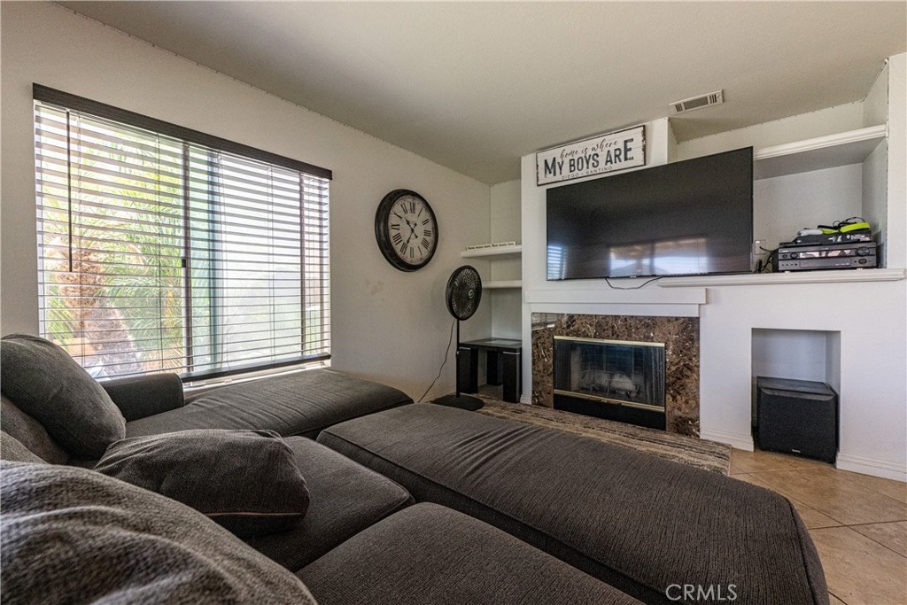 651 Viewpointe Lane Corona, CA 92881 - Photo 12 of 28 a living room with furniture a flat screen tv and a fireplace
