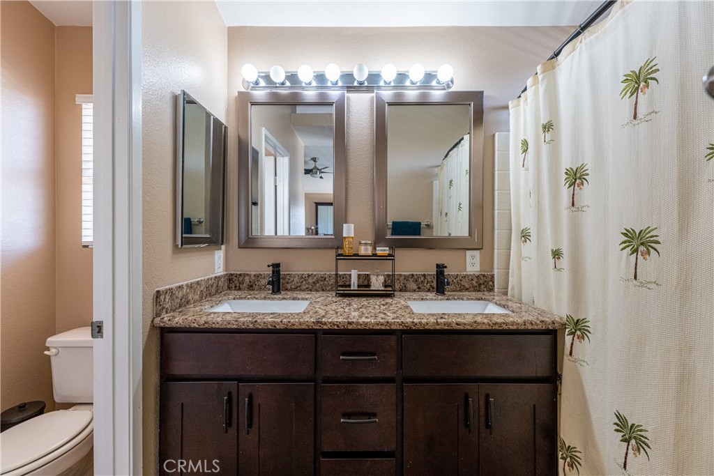 651 Viewpointe Lane Corona, CA 92881 - Photo 22 of 28 a bathroom with a granite countertop sink a large mirror and a shower