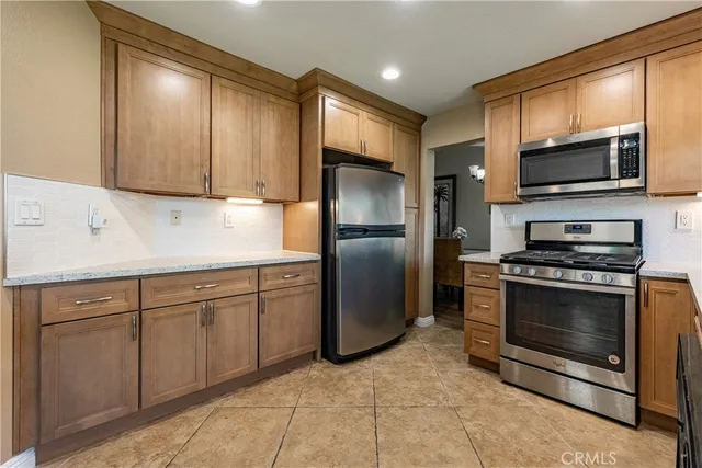 a kitchen with stainless steel appliances granite countertop a refrigerator microwave and sink