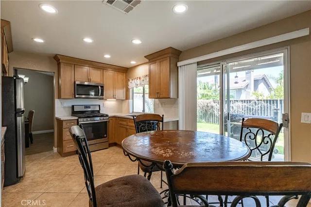 a kitchen with a dining table chairs and refrigerator
