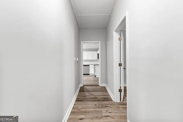 a view of a hallway with wooden floor