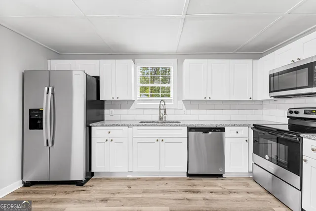 a kitchen with stainless steel appliances granite countertop a stove a sink and a refrigerator