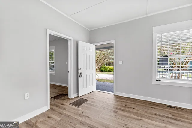 an empty room with wooden floor and a window