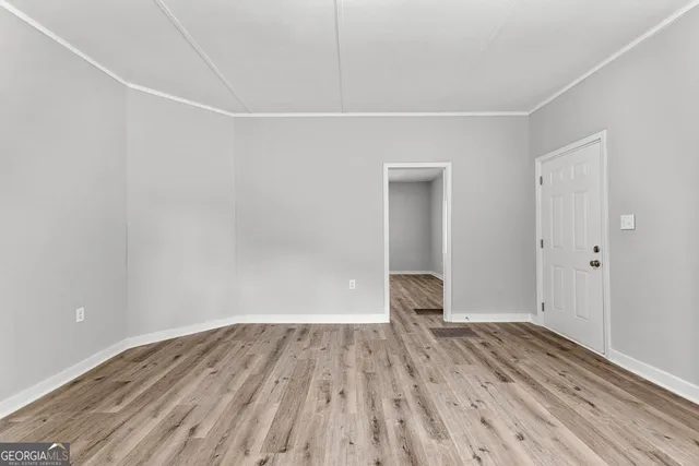 a view of empty room with wooden floor