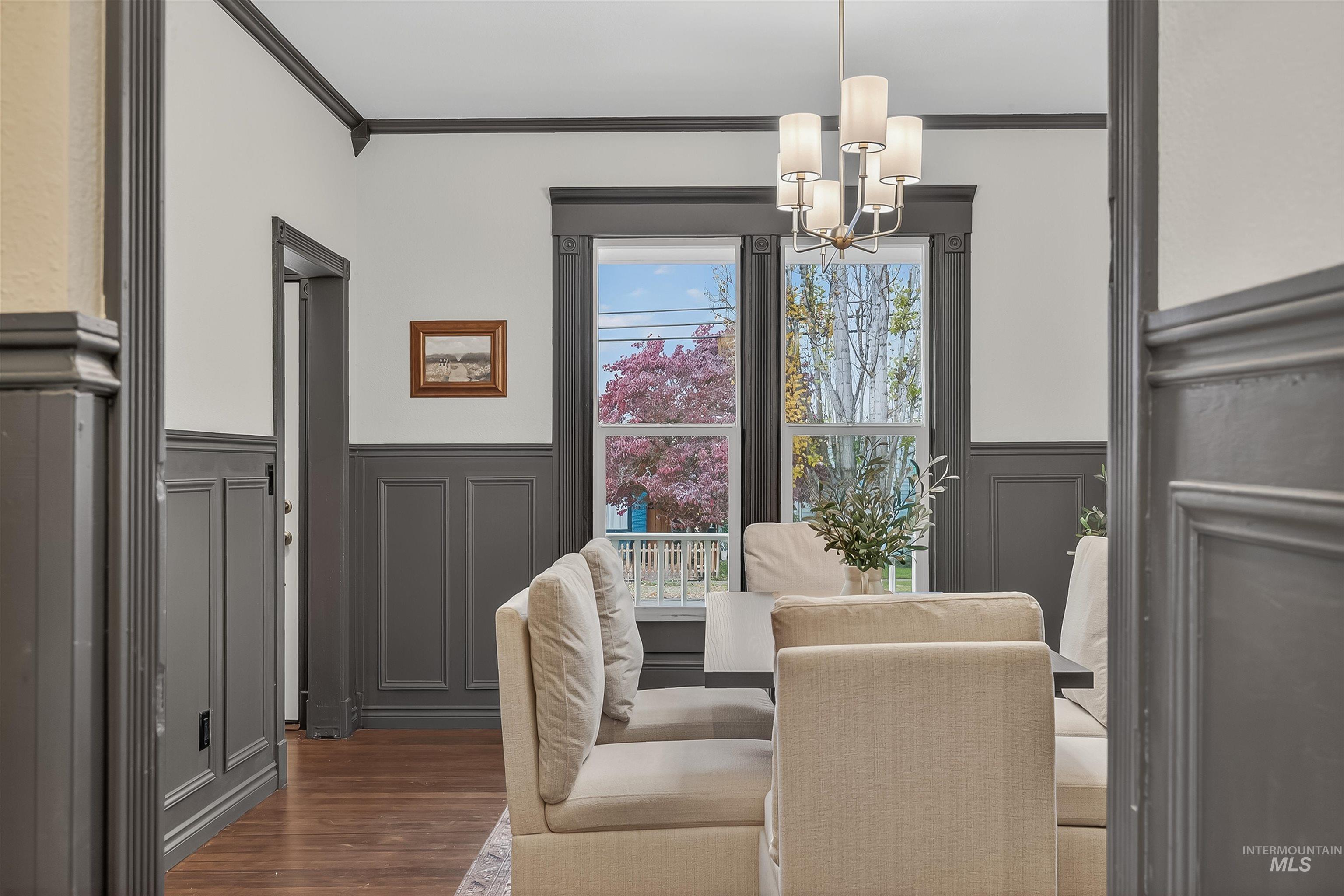 302 7th Avenue Lewiston, ID 83501 - Photo 11 of 50 Dining area with crown molding, wood finished floors, wainscoting, a chandelier, and a decorative wall