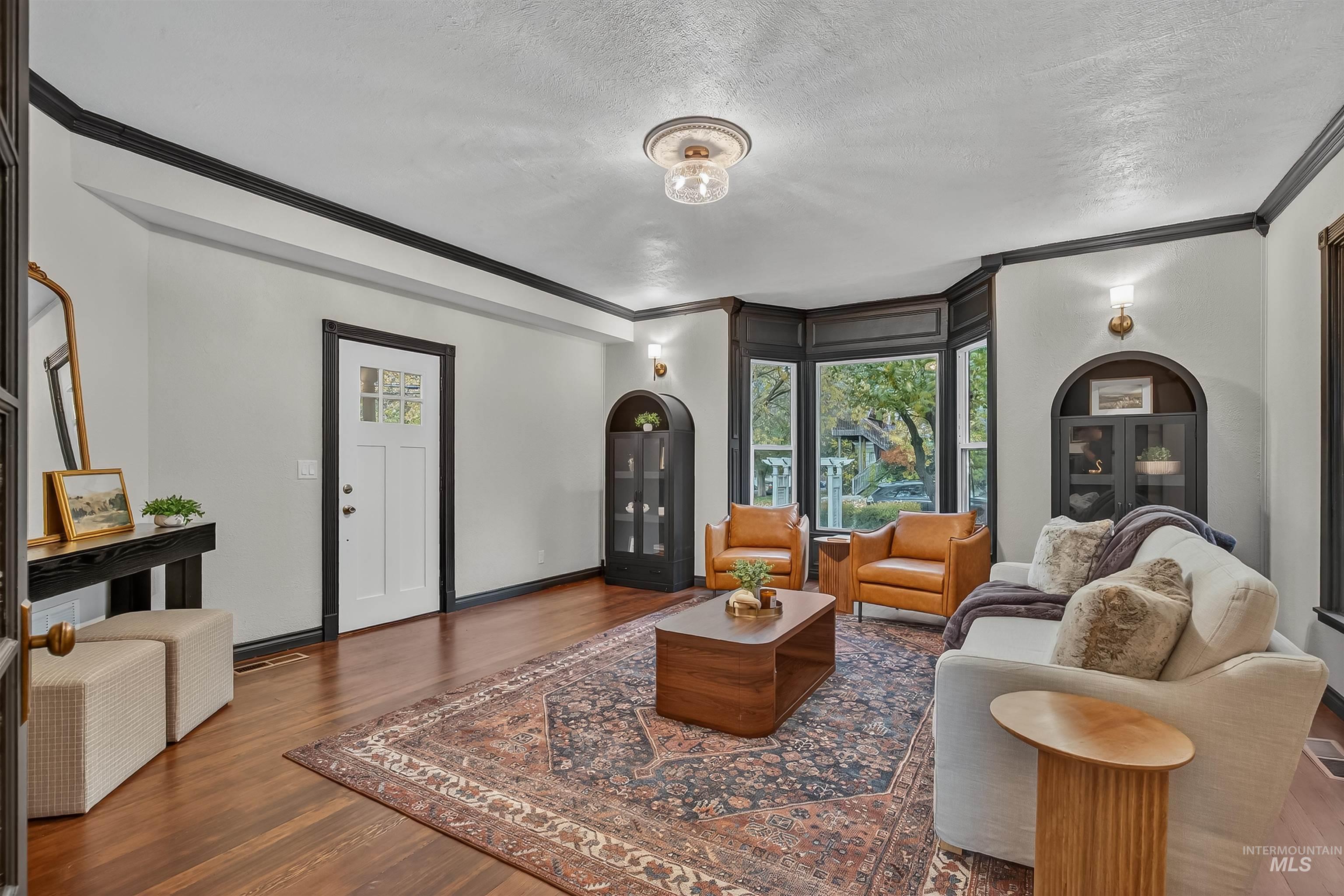 302 7th Avenue Lewiston, ID 83501 - Photo 13 of 50 Living room with ornamental molding, healthy amount of natural light, a textured ceiling, and wood finished floors