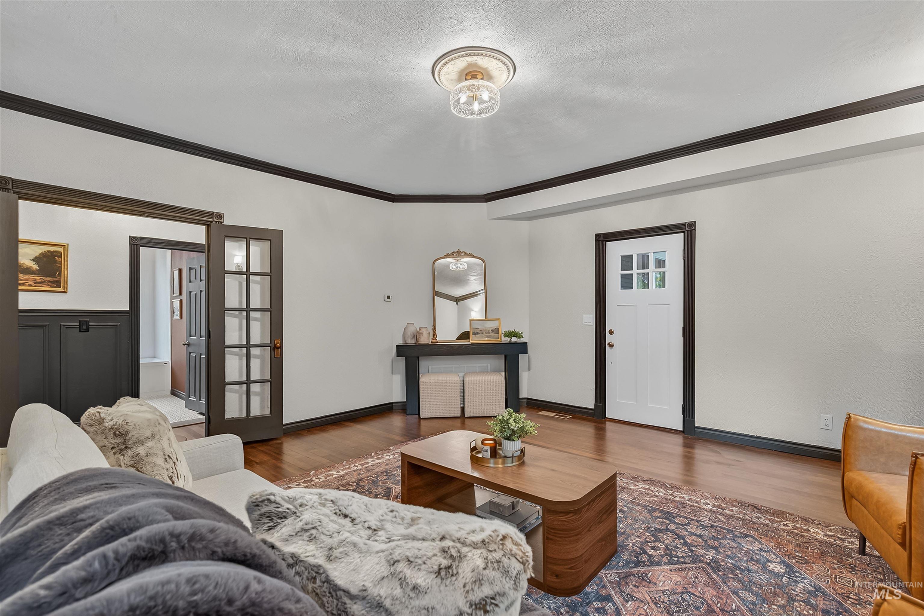 302 7th Avenue Lewiston, ID 83501 - Photo 14 of 50 Living room with wood finished floors, crown molding, a textured ceiling, and french doors