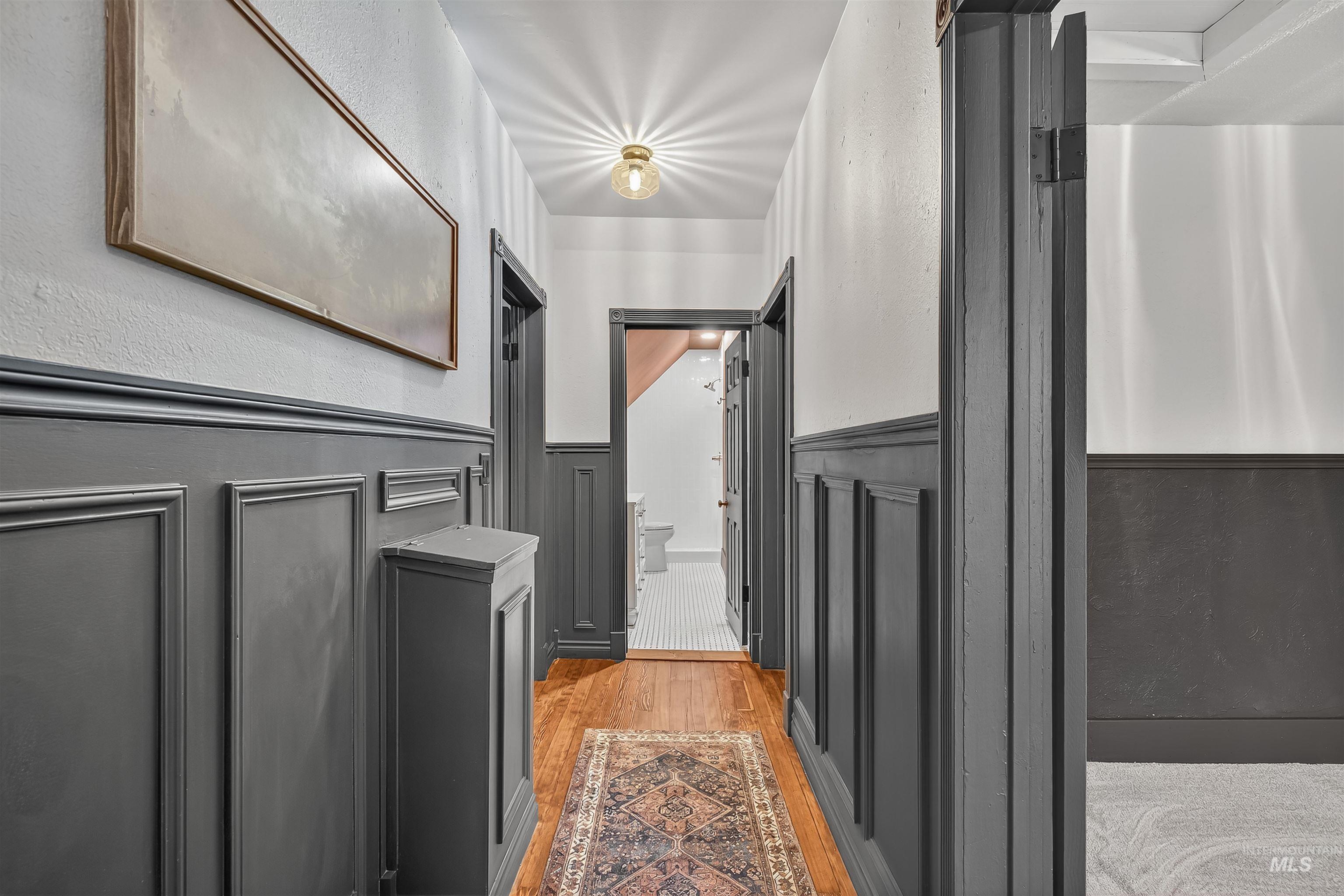 302 7th Avenue Lewiston, ID 83501 - Photo 22 of 50 Corridor featuring light wood-style flooring, wainscoting, a textured wall, and a decorative wall