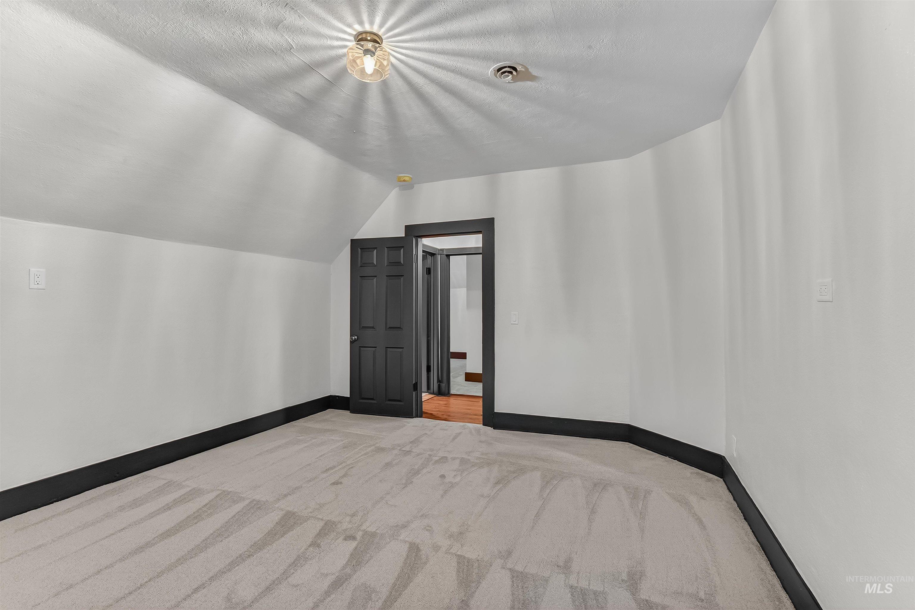 302 7th Avenue Lewiston, ID 83501 - Photo 24 of 50 Additional living space featuring light colored carpet, lofted ceiling, and a textured ceiling
