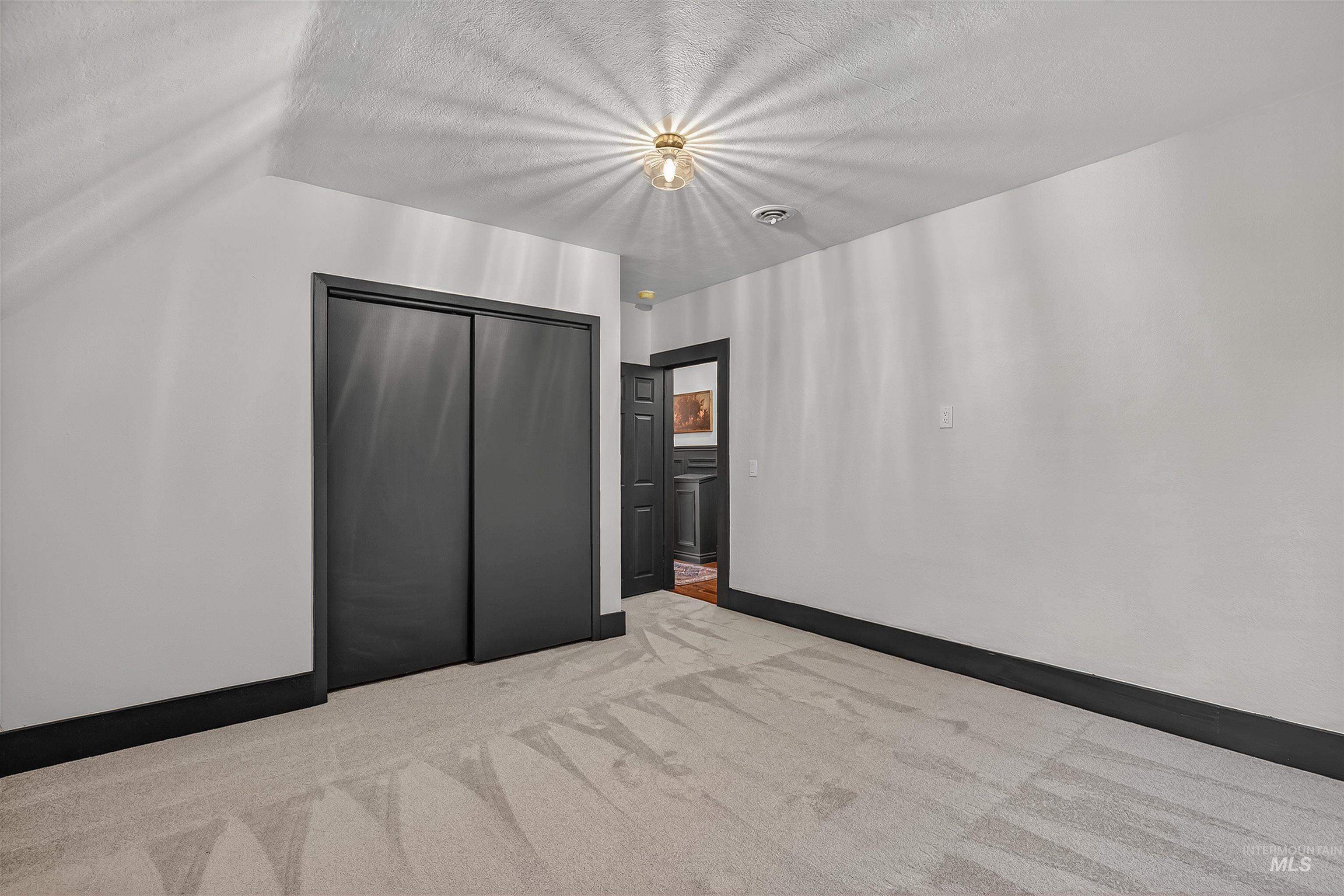 302 7th Avenue Lewiston, ID 83501 - Photo 29 of 50 Unfurnished bedroom featuring light carpet, a closet, and a textured ceiling